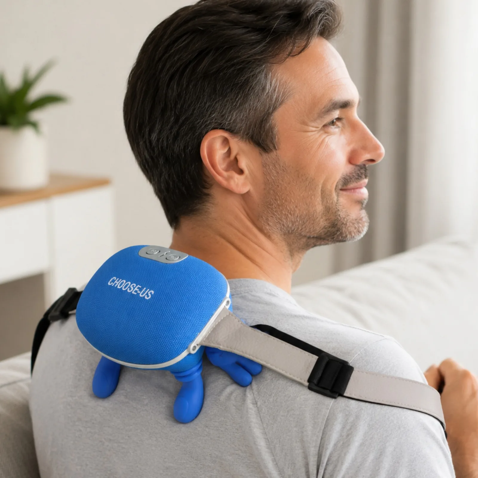 Man relaxing on a couch wearing the Choose-Us massager on his shoulder